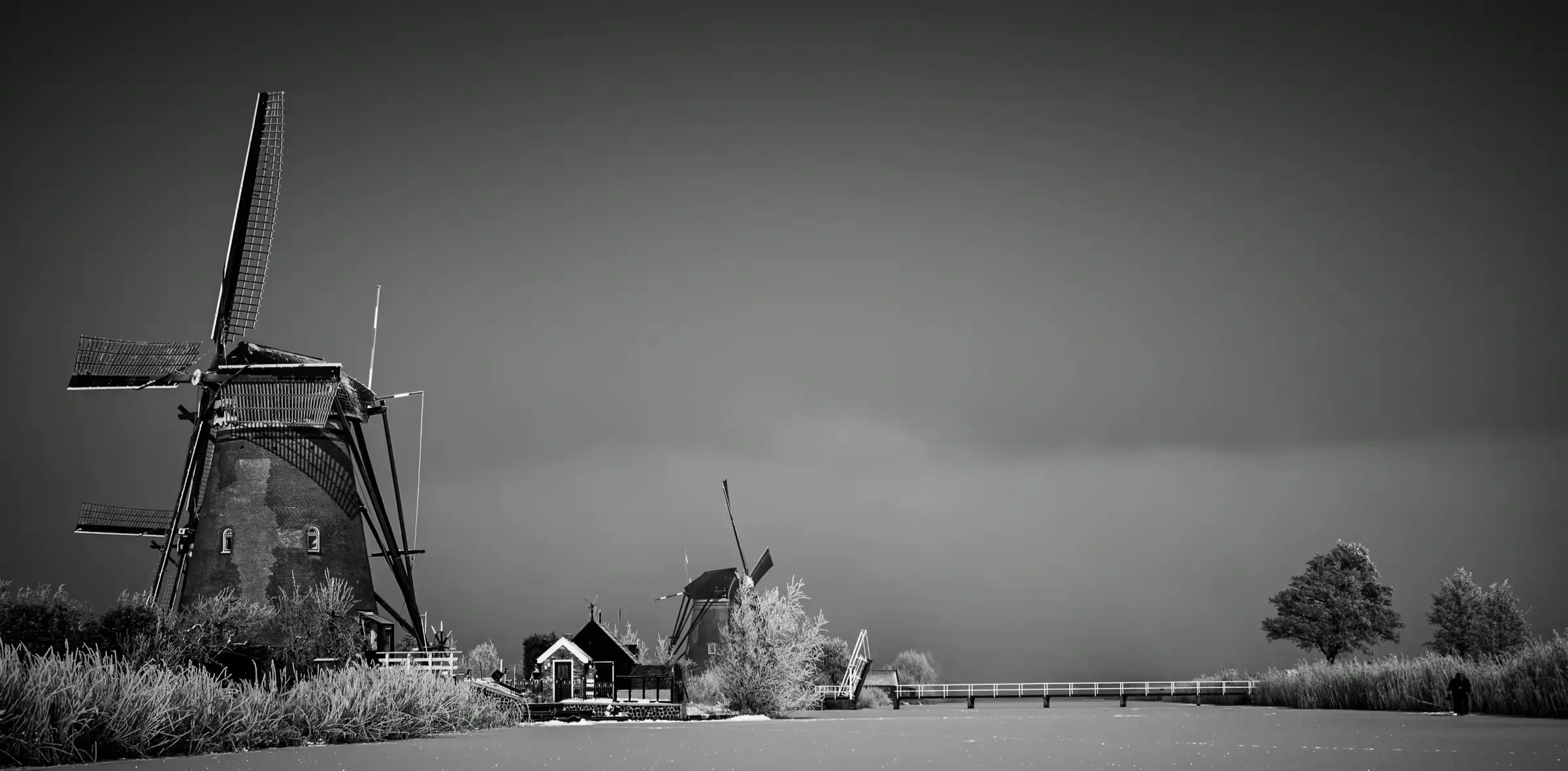 Windmills in Monochrome Mist Black-and-white photograph of the Kinderdijk windmills in mist.