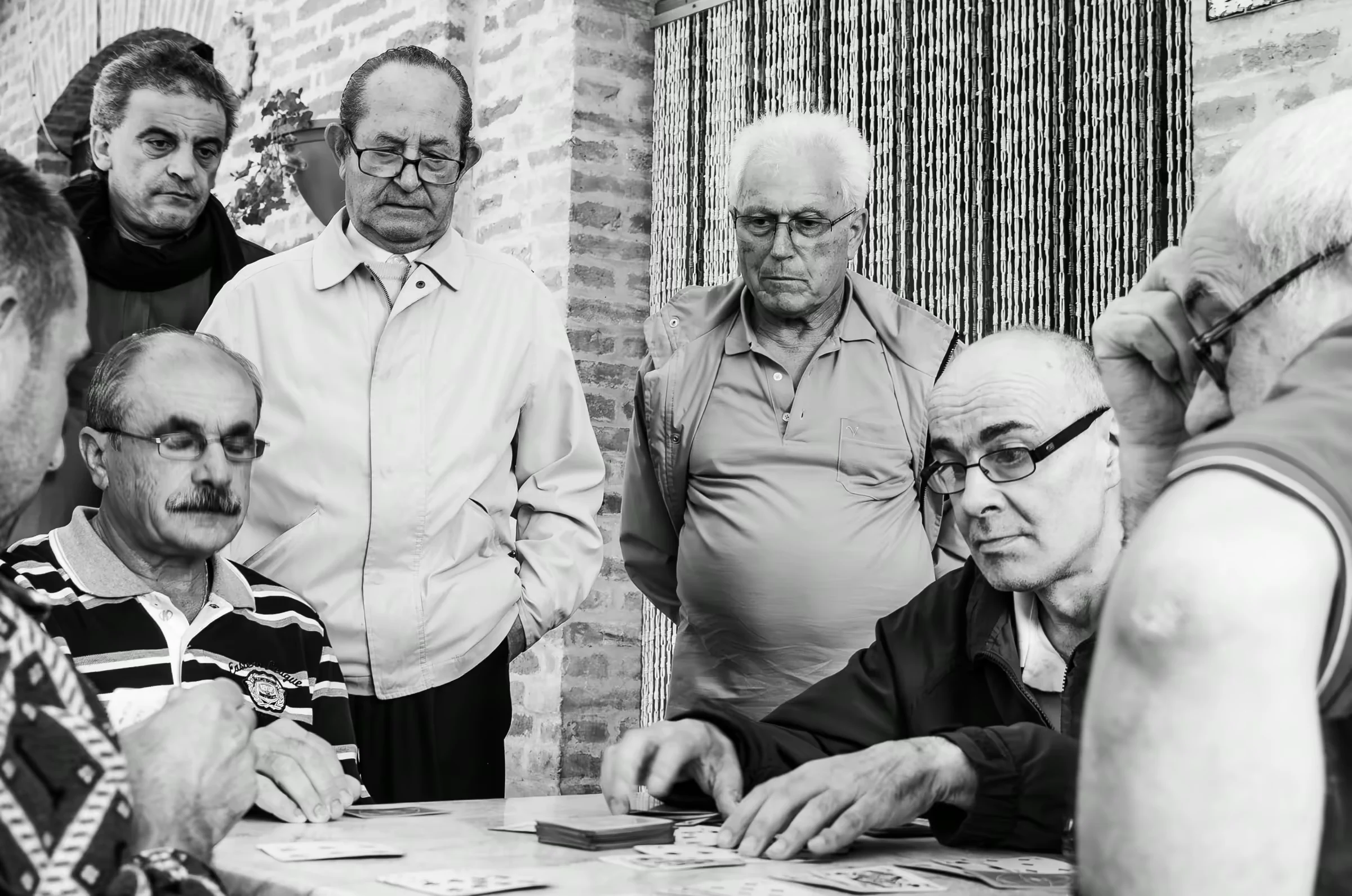 A group of older men playing cards.