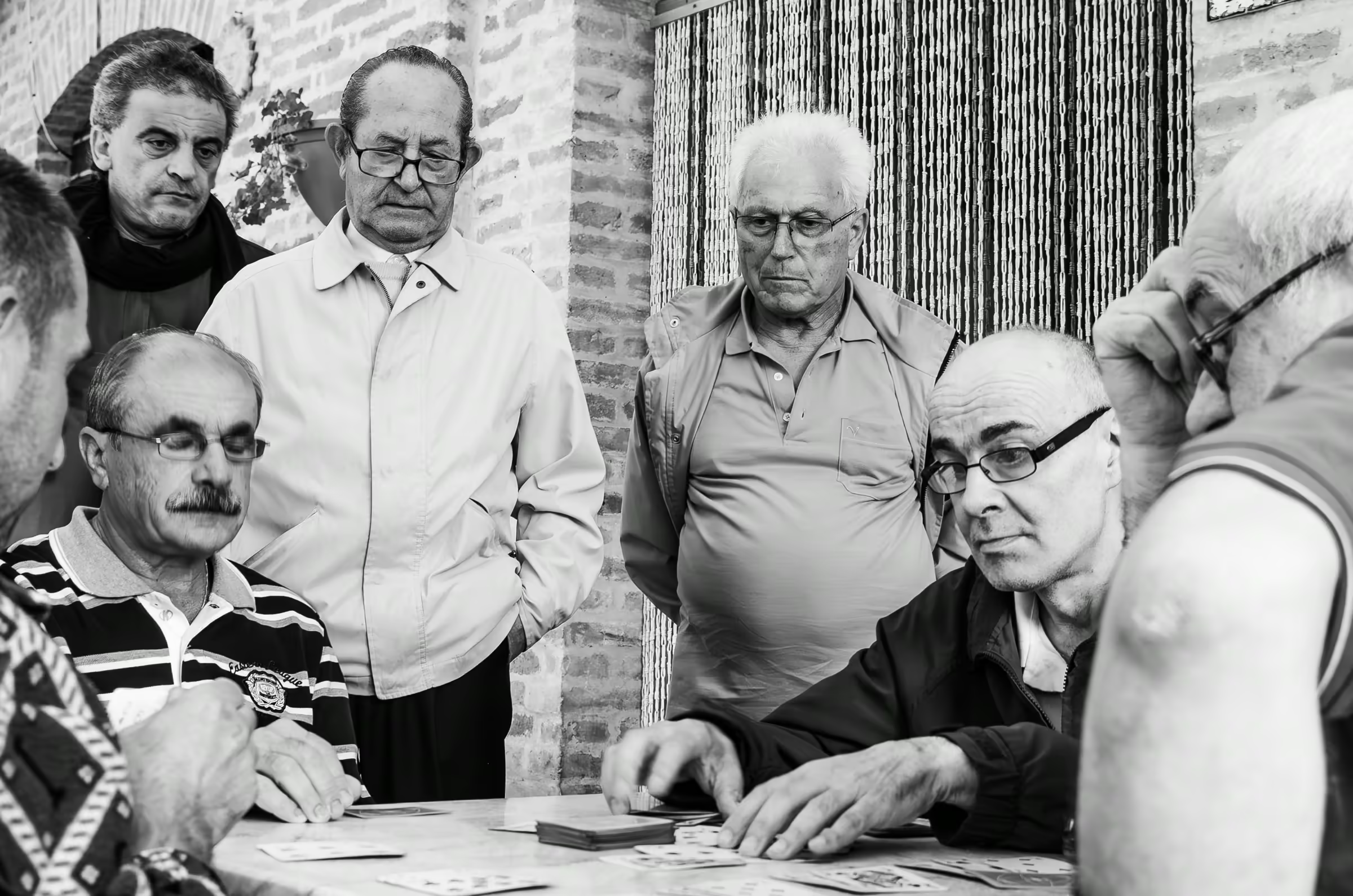 A group of older men playing cards.
