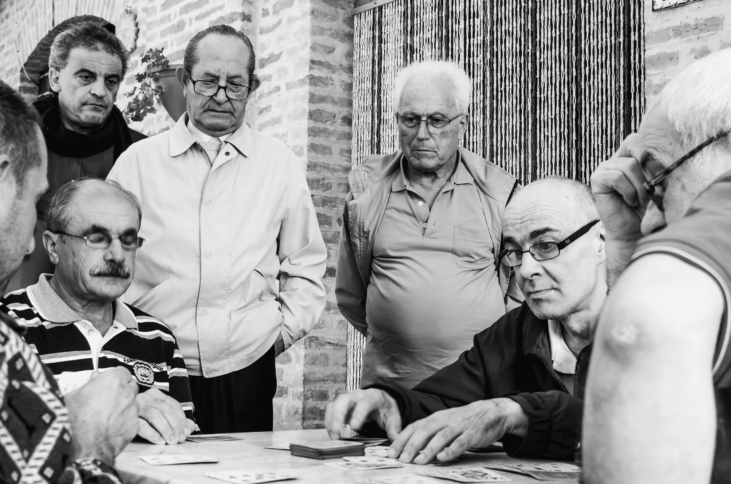 A group of older men playing cards.