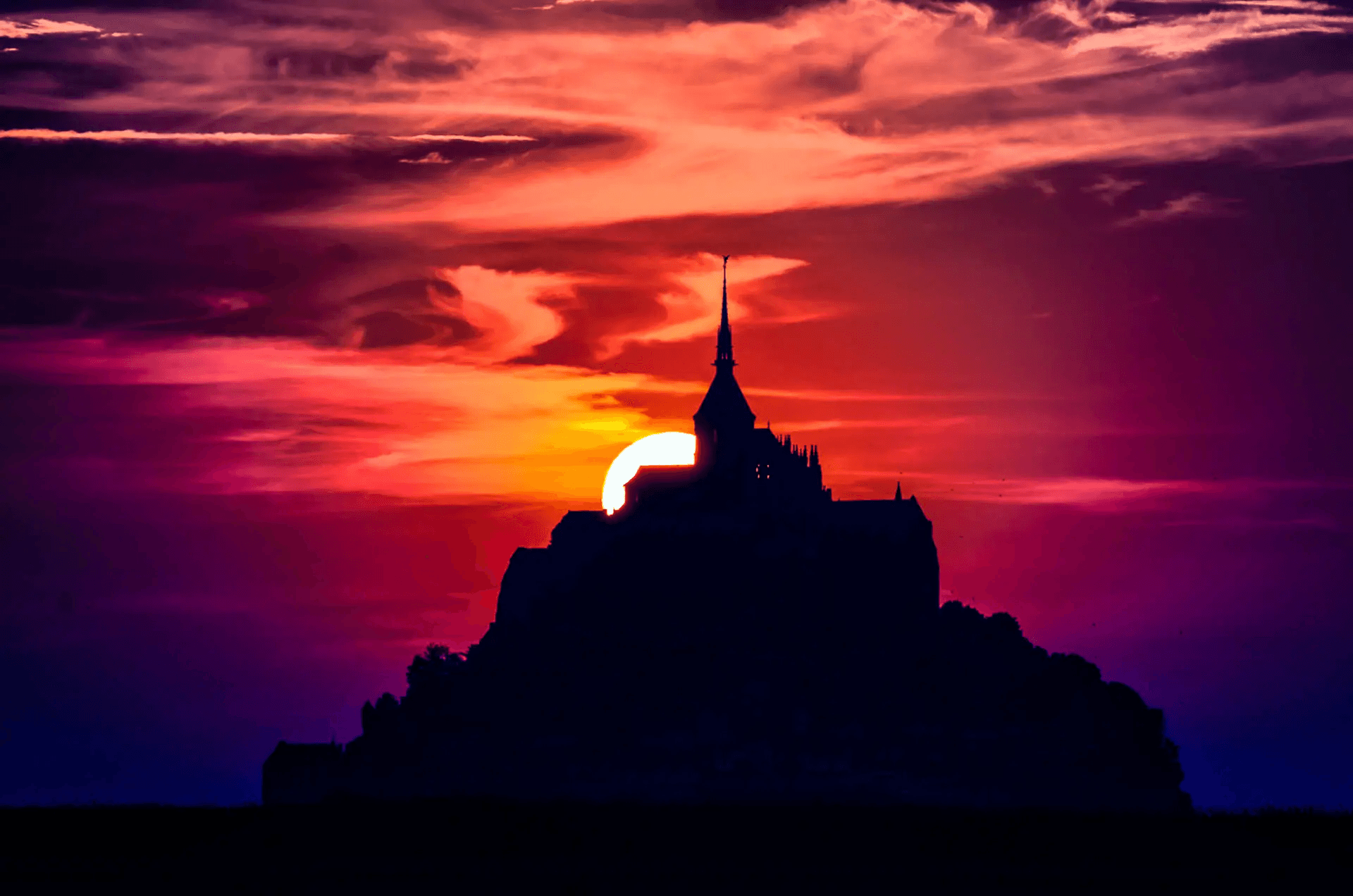 Mont Saint-Michel at Sunset's Edge Silhouette of Mont Saint-Michel, France, at sunset.