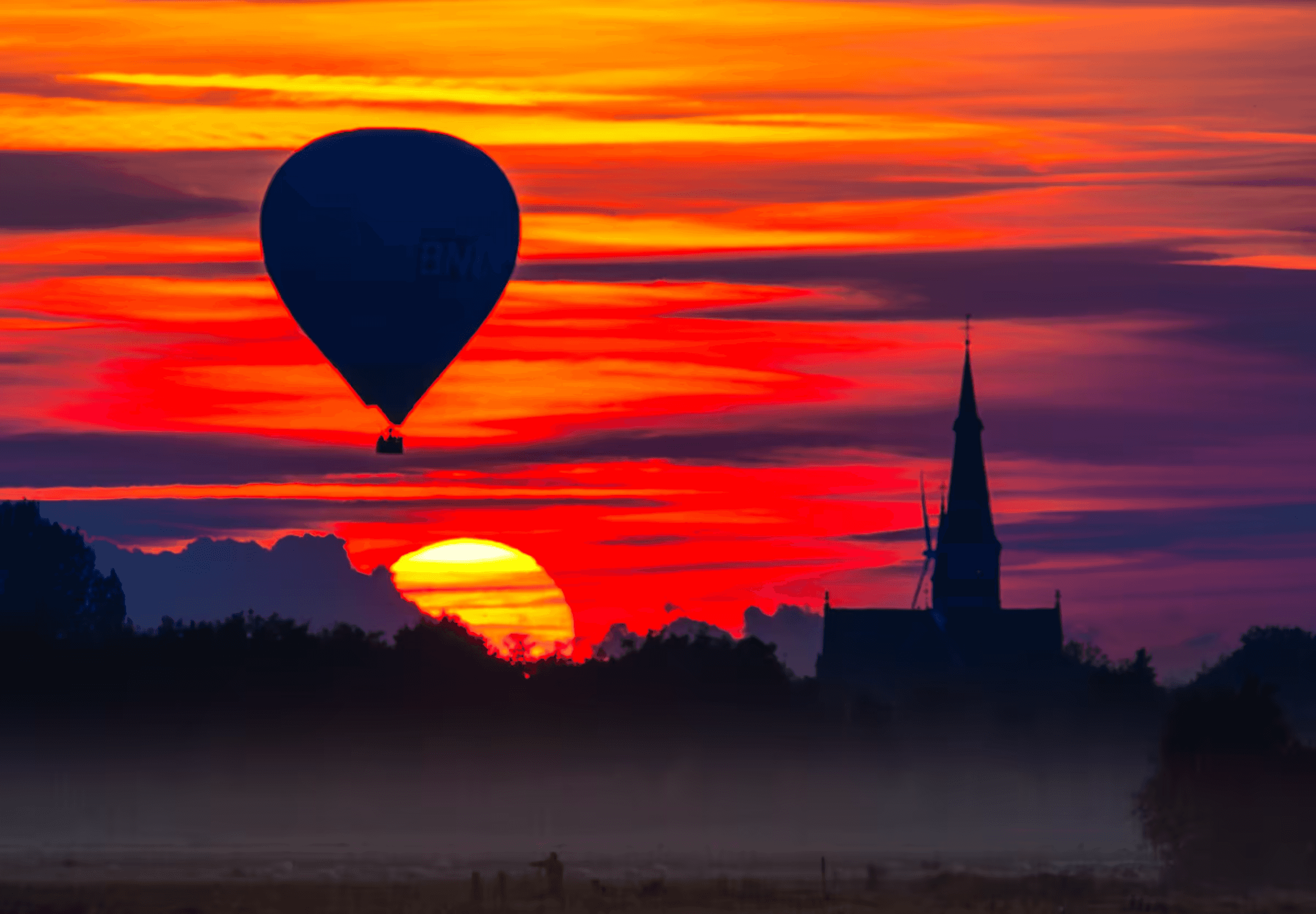 Landscape photograph of a hot air balloon silhouetted against a vibrant sunset in North Brabant, Netherlands.