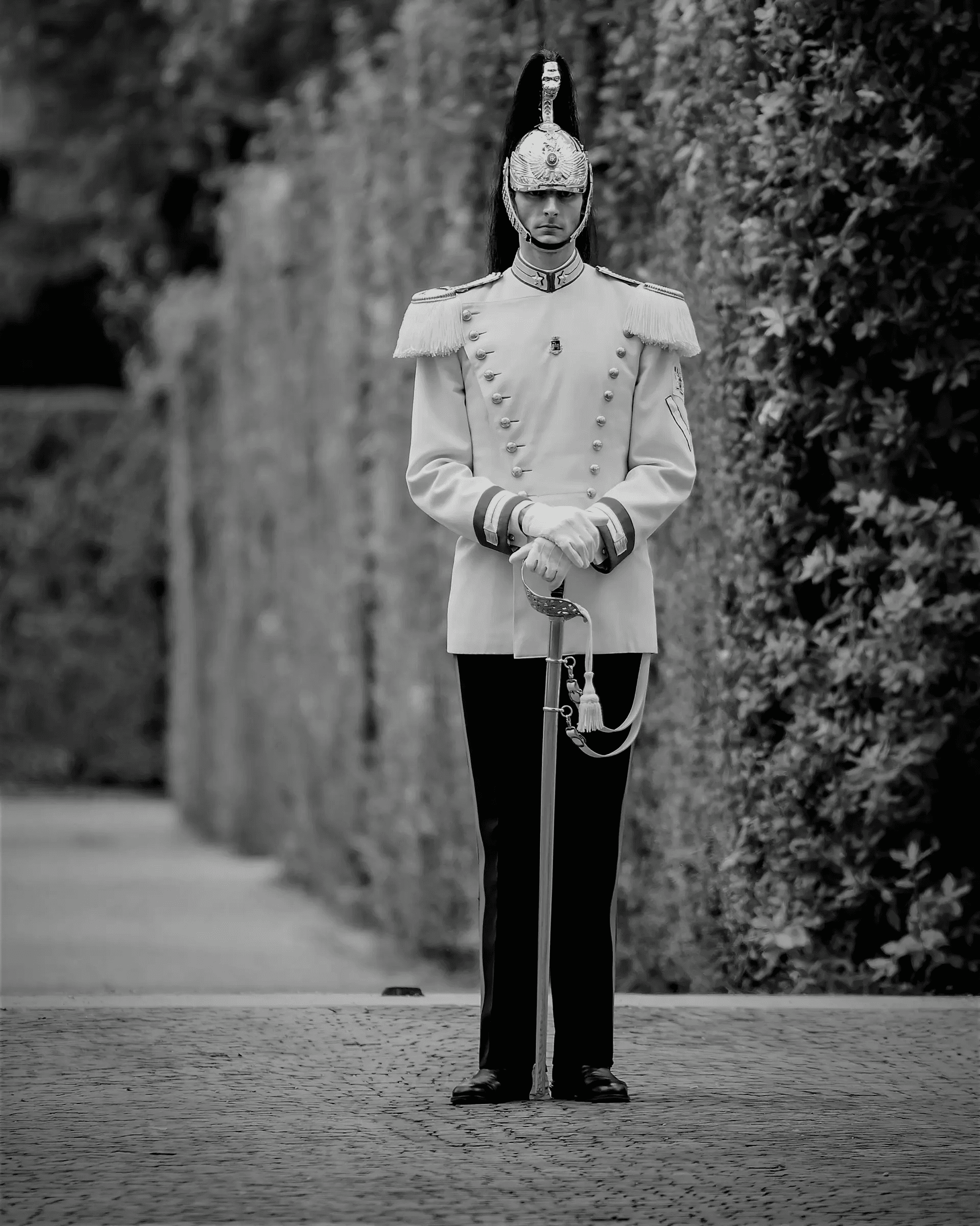 Black and white photograph of a Cuirassier standing at attention, guarding the Quirinal Palace in Rome, Italy.