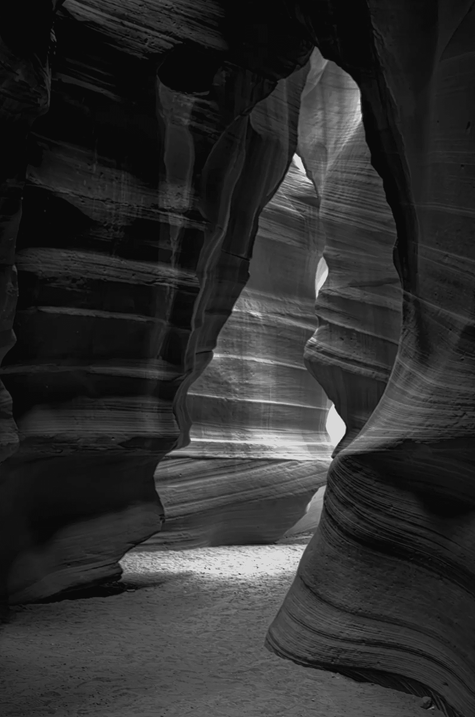 Strata of Time Monochrome layered view of sculpted sandstone walls and a light-filled passage in Antelope Canyon, Arizona.