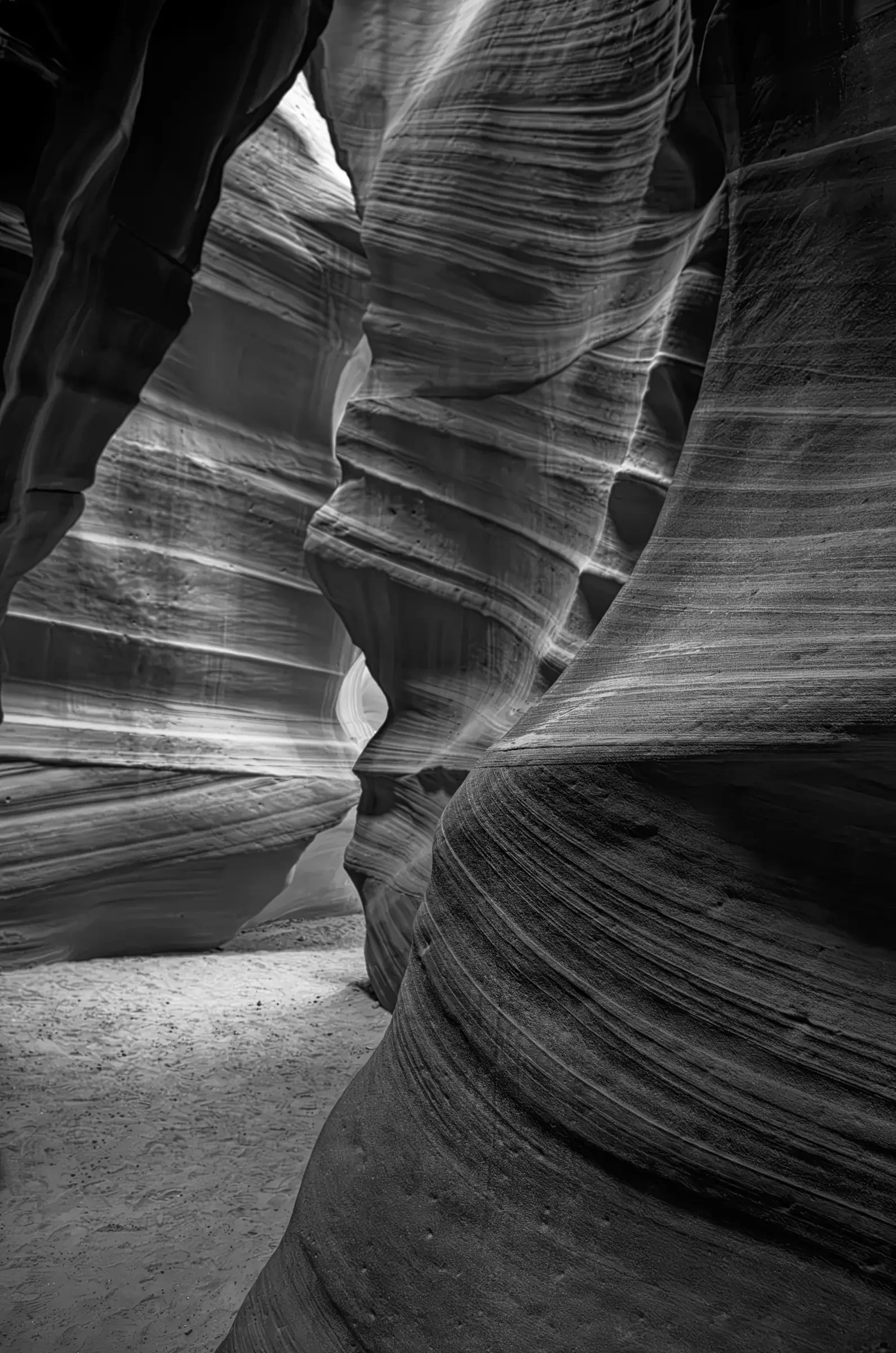 Monochrome view through the layered, curving sandstone walls of Antelope Canyon in Arizona.