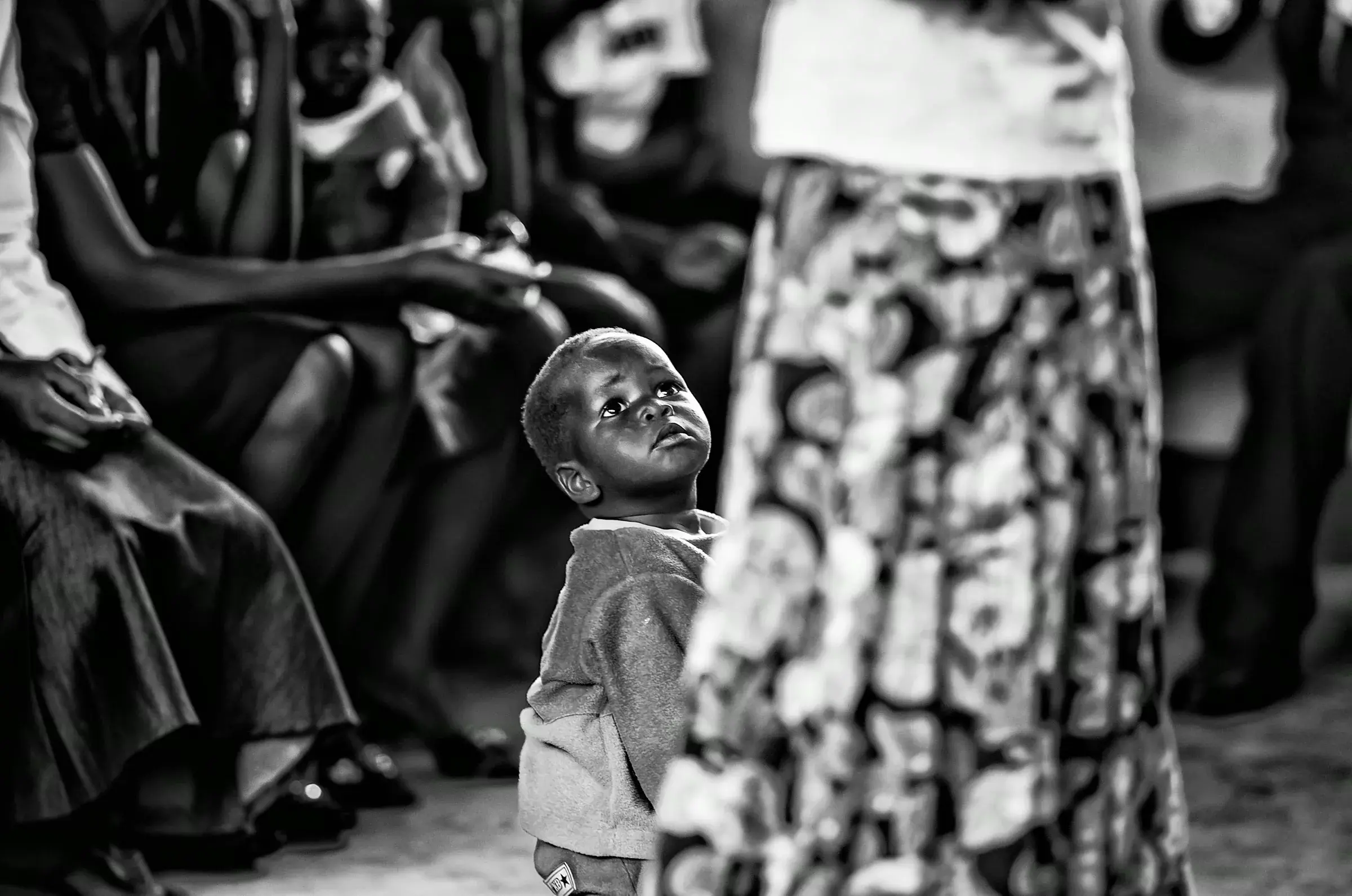 Black-and-white portrait of a child looking up in Uganda.