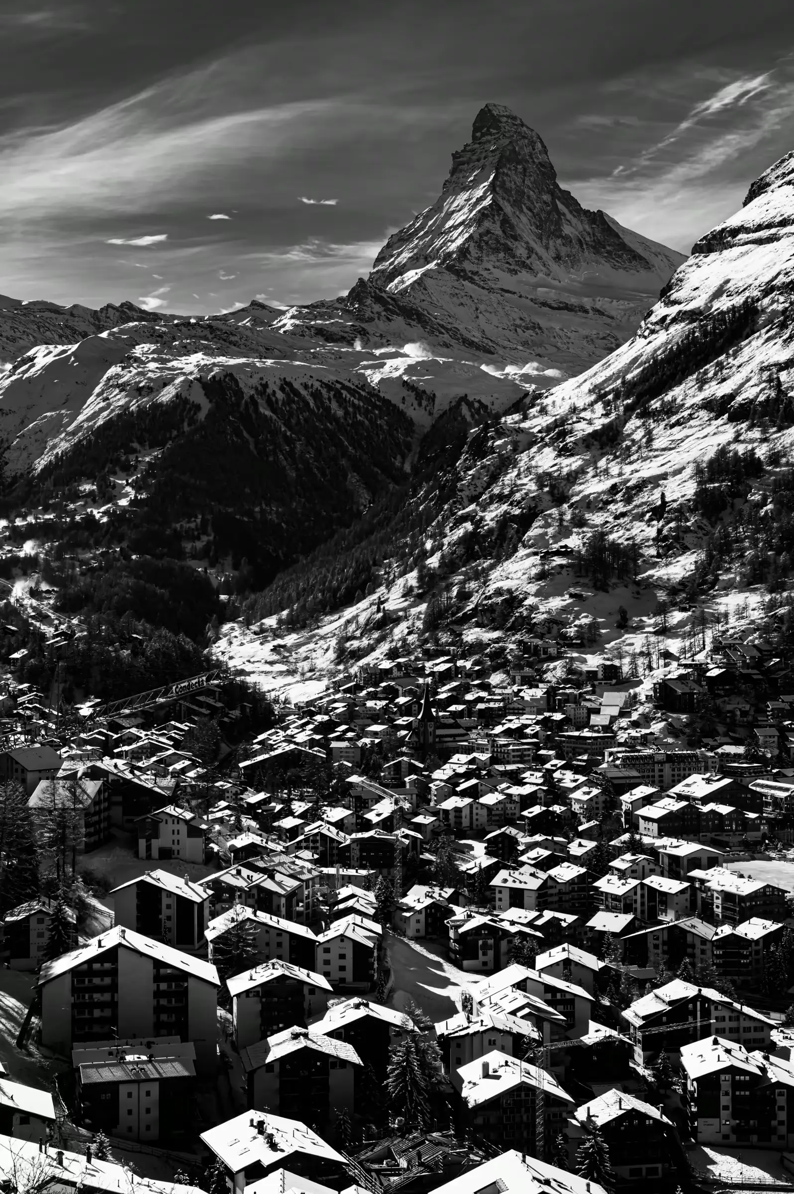 Black-and-white photograph of the Matterhorn above the snow-covered village of Zermatt.